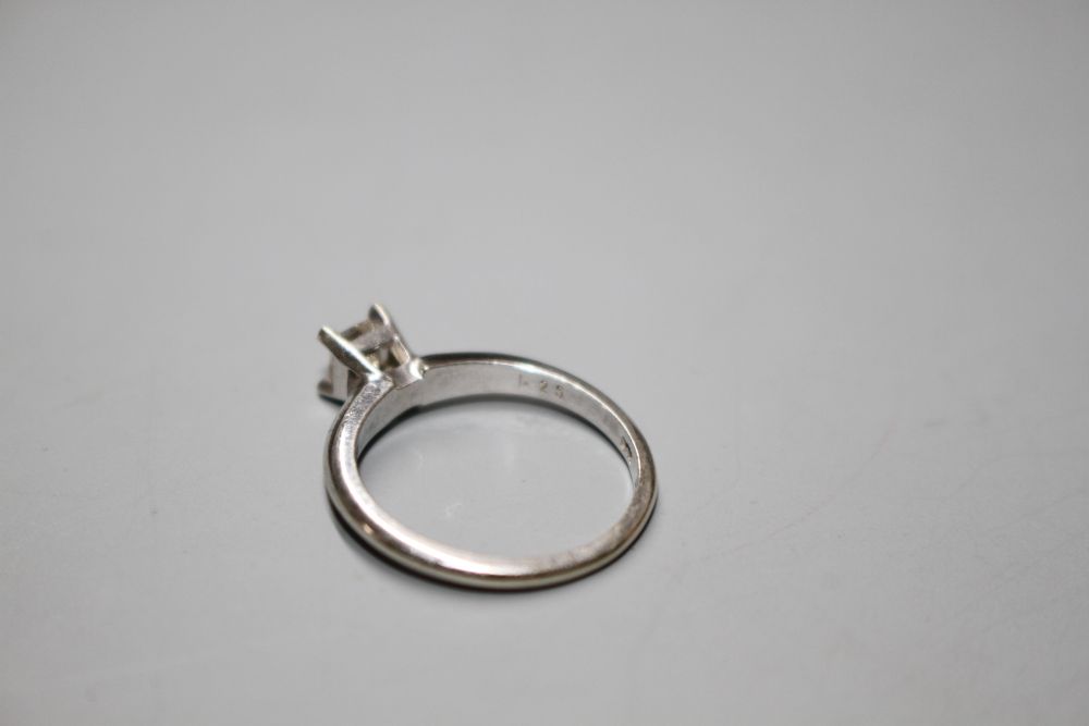 A modern 14k white metal and princess cut solitaire diamond ring, the stone weighing 0.25cts,